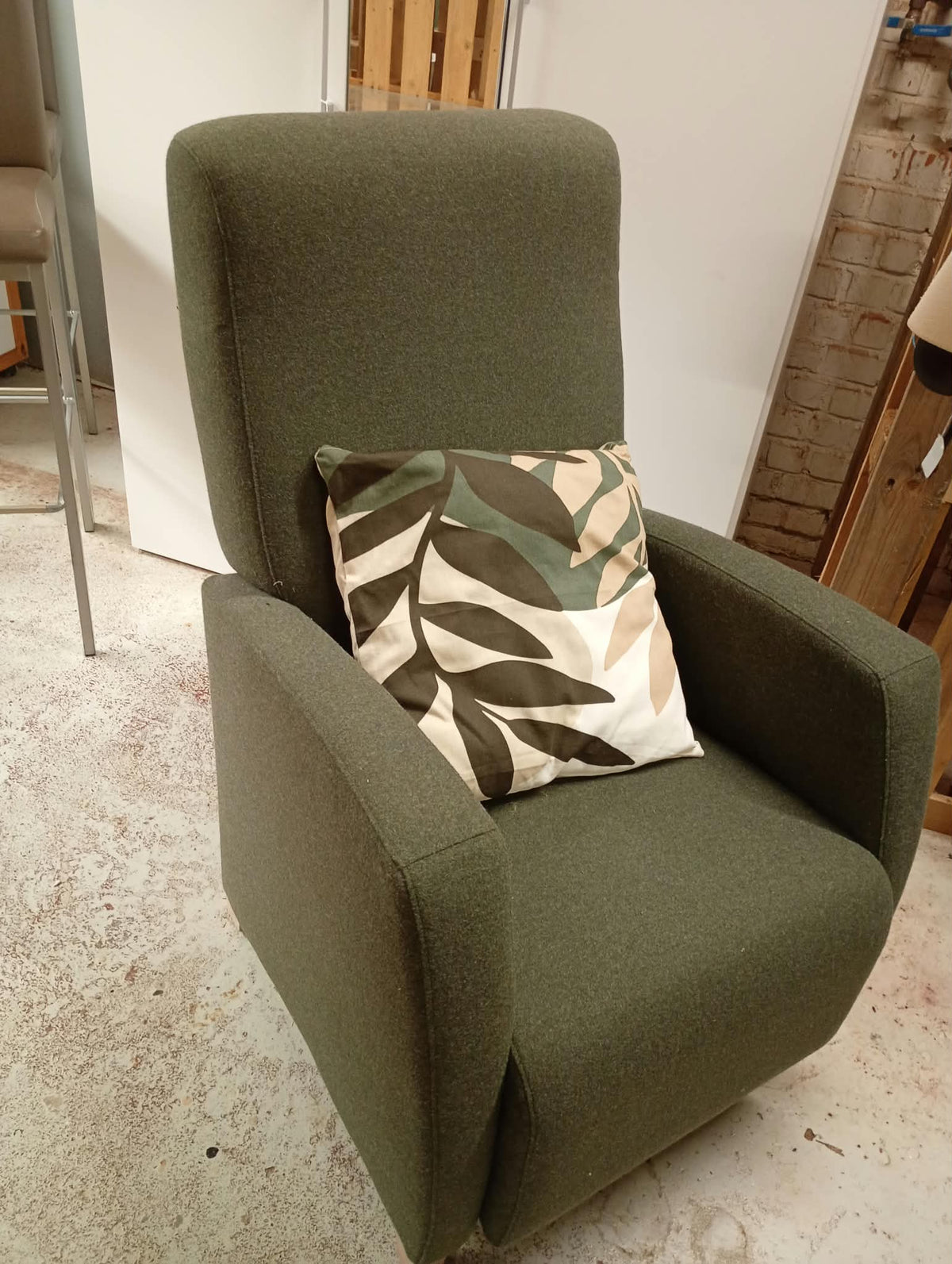 Olijfgroene fauteuil met een kussen met bladmotief