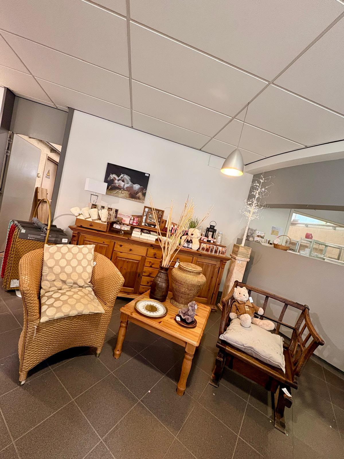 Ingericht hoekje met een rieten stoel, houten salontafel en grenen kast